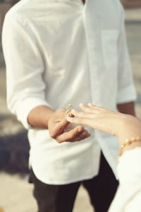 Man handing rings to woman pre wedding