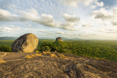 Scenic view of rocks on field against sky