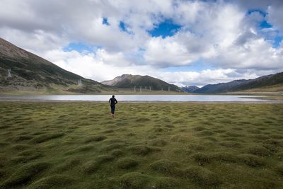 Full length of man on landscape against cloudy sky