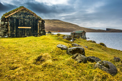 An old abandoned hamlet in the faroe islands. mountains and lake on background.