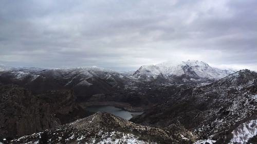 Scenic view of snowcapped mountains against cloudy sky