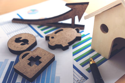 High angle view of graphs with model house and pen on table