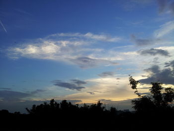 Silhouette of trees against cloudy sky