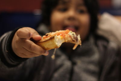 Boy holding pizza slice