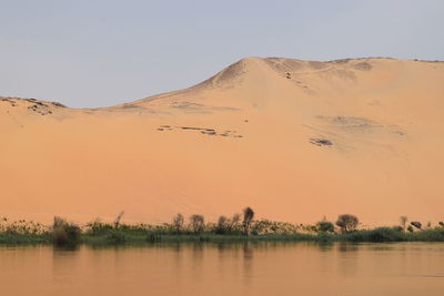 Scenic view of lake against clear sky during sunset