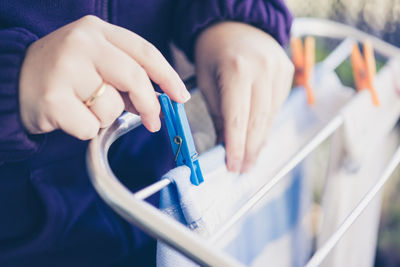 Midsection of person drying laundry on clothesline