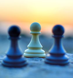 Close-up of chess pieces on sand