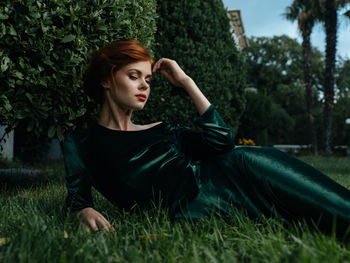 Young woman sitting on grassy field