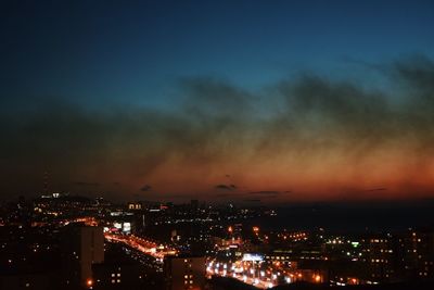 High angle view of illuminated buildings against sky at night