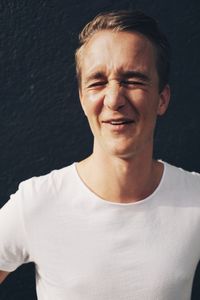 Portrait of smiling young man against black background