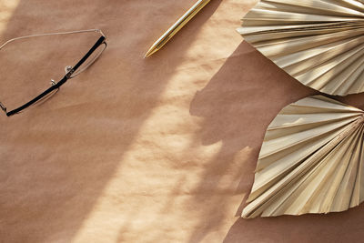 Minimal stationery still life. dry palm leafs, glasses and pen on craft paper. flat lay composition 