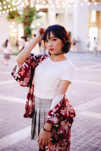 Portrait of young woman standing in city
