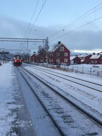 Railroad tracks against sky during winter
