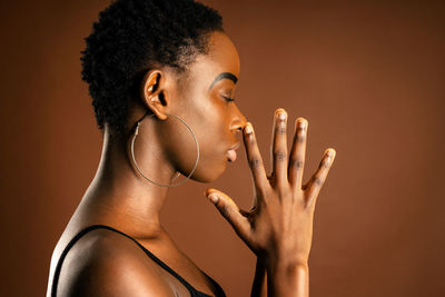 Portrait of young woman against gray background