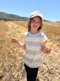 Portrait of young woman standing on field
