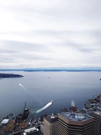 High angle view of sea by cityscape against sky