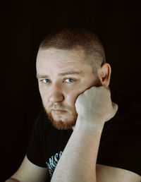 Close-up of young man against black background