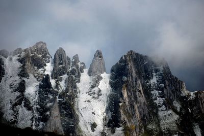 Low angle view of snowcapped mountains against sky