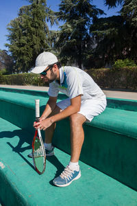 Tennis player sitting in court