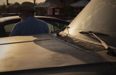 Portrait of adult man in cowboy hat standing against truck