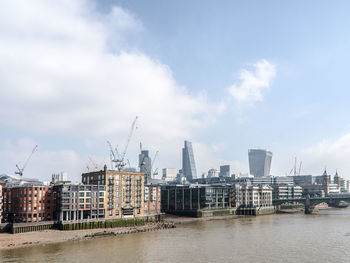 River in city against cloudy sky