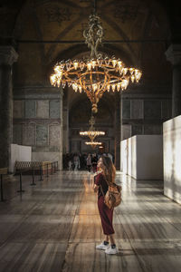 Full length of woman standing against illuminated building