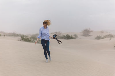 Full length of woman on sand against sky