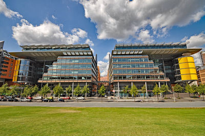 Buildings in city against cloudy sky