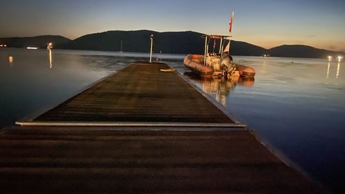 Pier over sea against sky at sunset