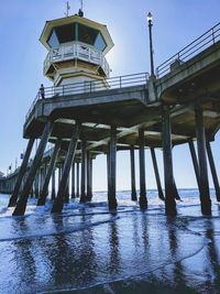 Low angle view of pier on sea against clear sky