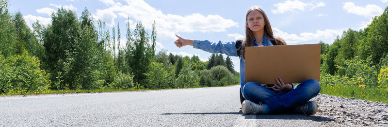 Rear view of man sitting on road