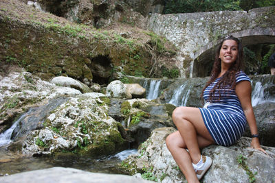 Girl summer vacation in the mountains at river in candalla falls under rock bridge in tuscany lucca