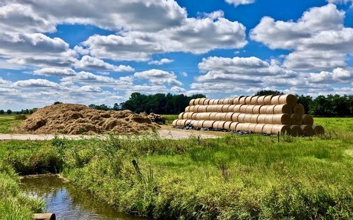 Hay bales on field against sky