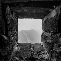 Mountain in foggy weather seen through window in great wall of china