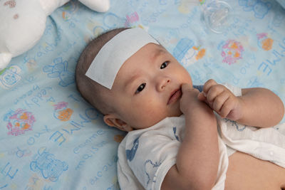 Portrait of cute baby lying on bed