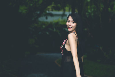 Portrait of smiling young woman standing outdoors