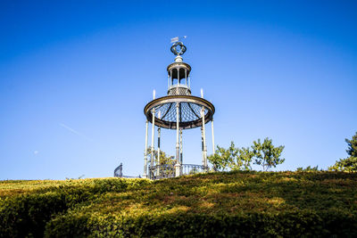 Low angle view of communications tower against clear blue sky