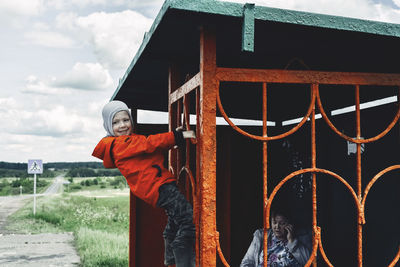 Cheerful boy playing with grandmother sitting inside built structure