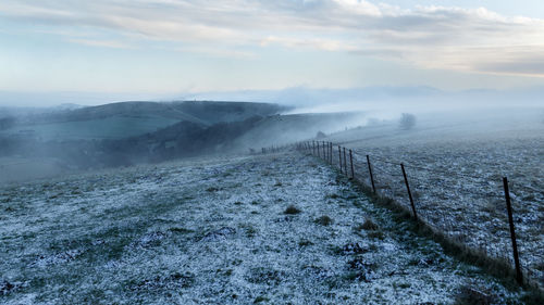 Scenic view of snow covered land against sky