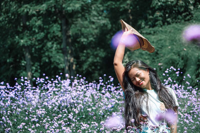 Woman standing on purple flowering plant