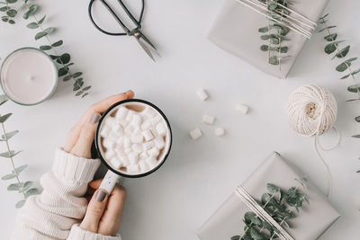 Cropped hands of woman having hot chocolate at table