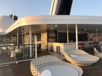 Chairs and tables in restaurant against sky