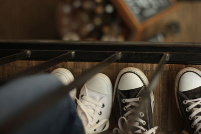 Low section of people wearing canvas shoes standing by railing