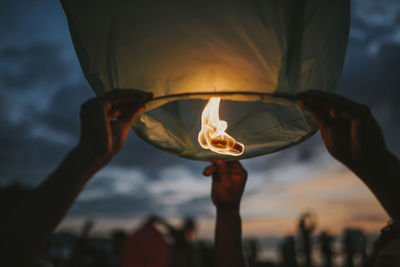 Close-up of hand holding lit candle