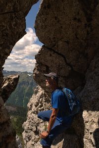 Side view of man looking at rock formation