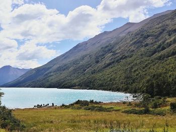 Scenic view of lake by mountains against sky