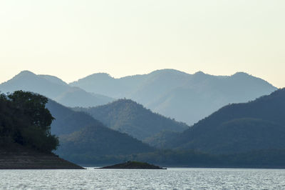 Scenic view of sea and mountains against clear sky