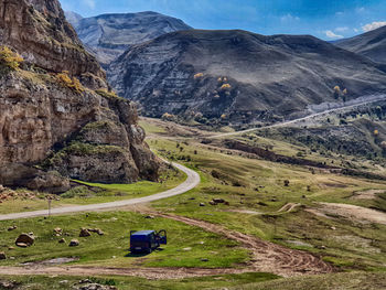 Scenic view of road by mountains against sky