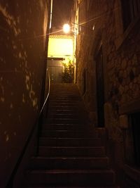 Walkway in illuminated city at night