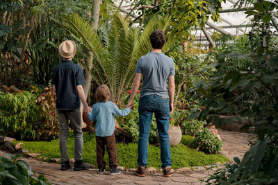 Adventurous family inspecting tropical gallery in botanical garden. local travel